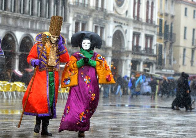 Costumed revellers walk on St Mark's square covered with snow during the carnival on February 11, 2013 in Venice. The 2013 edition of the Venice carnival is untitled " Live in Colour" and runs from January 26 to February 12. AFP PHOTO / ANDREA PATTARO (Photo credit should read ANDREA PATTARO,ANDREA PATTARO/AFP/Getty Images)