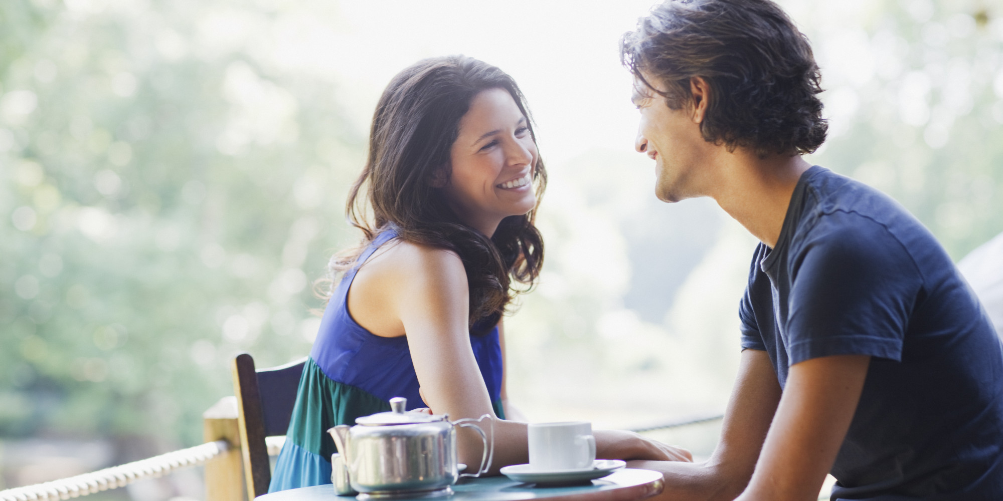 Smiling couple having tea outdoors